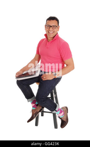 Ein glücklicher Hispanic Mann auf einem Stuhl sitzend Lächeln, mit dem Mew Papier und seinen Tablet auf seinem Schoß für weißen Hintergrund isoliert Stockfoto