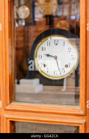 alte Retro-Uhr mit römischen Ziffern hinter Glas Stockfoto