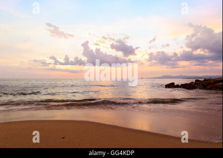 Ocean Sunset ist eine weiche Pastell farbigen Strandlage mit einem detaillierten Wolkengebilde und einer sanften Welle ans Ufer Rollen. Stockfoto