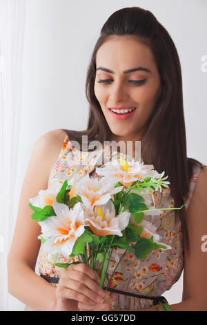 Überraschung junge indische Frau mit Blumenstrauß zu Hause Stockfoto
