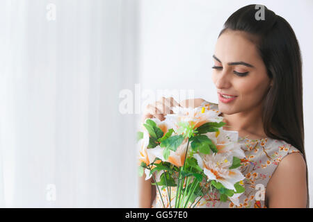 Schöne junge Frau mit Blumenstrauß Stockfoto