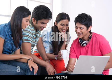Glückliche Freunde mit Laptop in der Schule Stockfoto