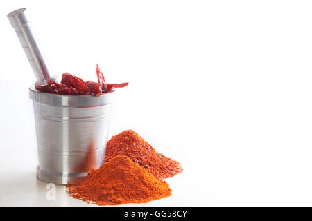 Chili-Pulver mit Chilis im Mörser und Stößel auf weißem Hintergrund Stockfoto