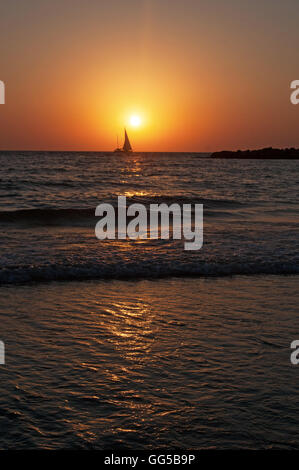 Tel Aviv, Israel, Naher Osten: der Strand, ein Segelboot und das Mittelmeer bei Sonnenuntergang am Ende eines wunderschönen Sommertag Stockfoto