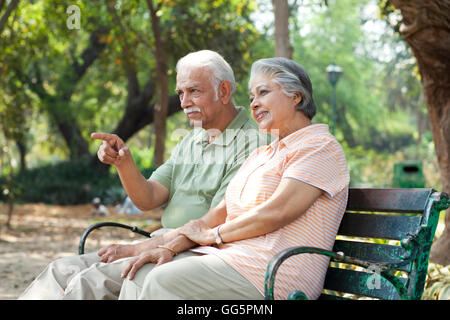 Senior woman zeigt auf etwas interessantes und verbringt Zeit mit Frau im park Stockfoto