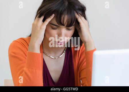 Nahaufnahme einer jungen Frau, die unter Kopfschmerzen leiden Stockfoto