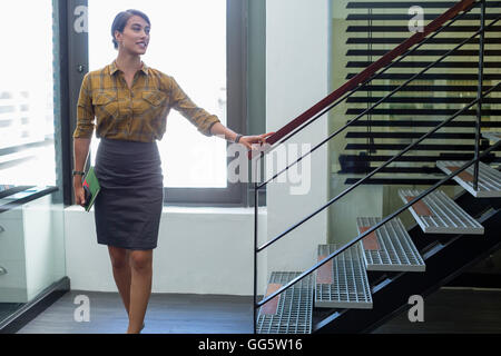 Geschäftsfrau, die zu Fuß durch Büro Treppe Stockfoto