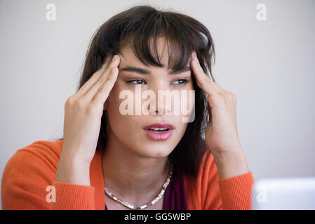 Nahaufnahme einer jungen Frau, die unter Kopfschmerzen leiden Stockfoto