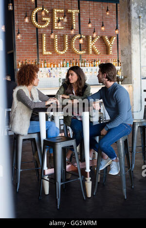 Freunde sprechen am Café-Tisch Stockfoto