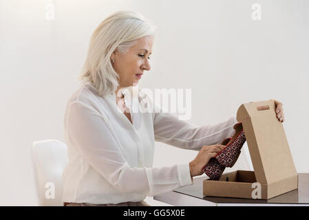 Seitenansicht einer Frau, die Eröffnung eines Grundstücks Sandale Stockfoto
