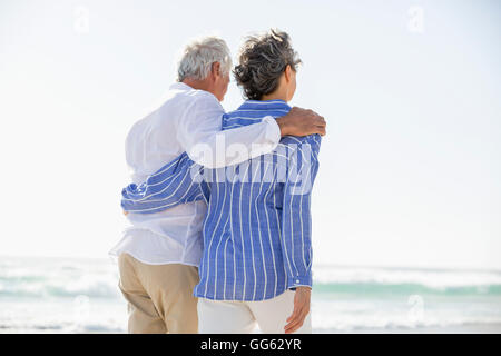Rückansicht des ein paar stehend mit Arm umeinander am Strand Stockfoto