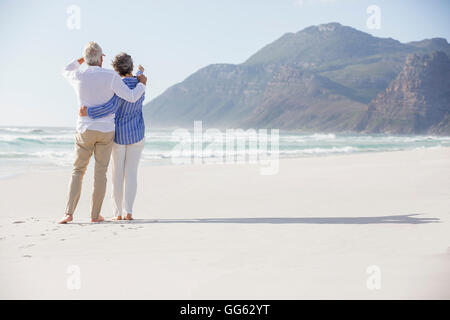 Rückansicht des ein paar stehend mit Arm umeinander am Strand Stockfoto