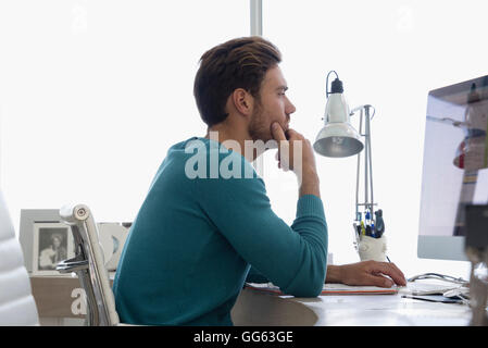 Junger Geschäftsmann auf Computer in einem Büro arbeiten Stockfoto