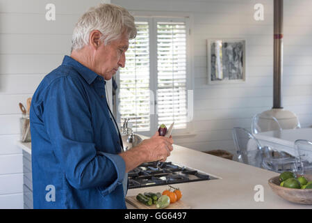 Senior woman, die Vorbereitung von Gemüse in der Küche Stockfoto