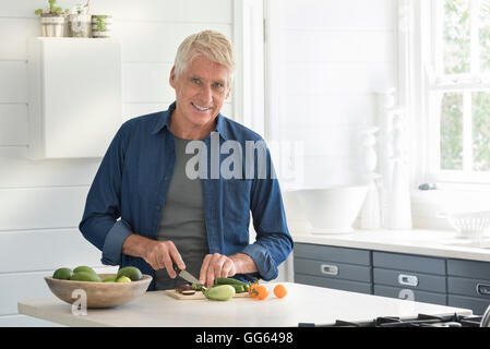 Happy senior woman vorbereiten Gemüse in der Küche Stockfoto