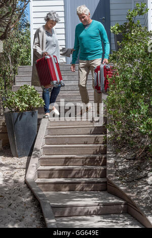 Gerne älteres Paar mit Koffer auf Treppe Stockfoto