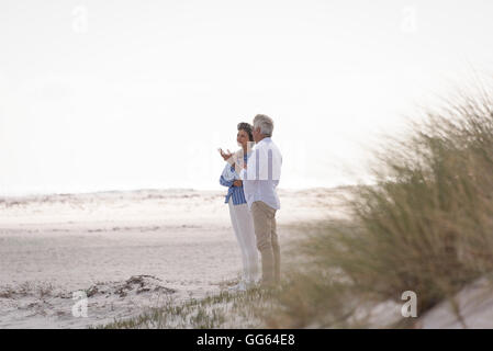 Gerne älteres Paar am Strand sprechen Stockfoto