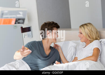 Junges Paar Lächeln sich gegenseitig auf dem Bett Stockfoto