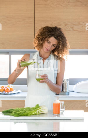 Frau Gemüsesaft in ein Glas gießen Stockfoto