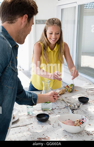 Glückliches Paar Essen am Tisch Stockfoto