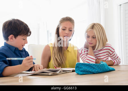 Mutter und Kinder Hausaufgaben auf Tisch Stockfoto