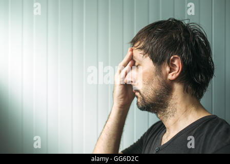 Profil Portrait Od Elend unruhigen Mann mit schweren Ausdruck, depressiver Mann mit Hand auf Gesicht. Stockfoto