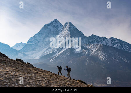 Wanderer erklimmen eine kleine Spitze oben Dingboche in der Everest Region mit Ama Dablam in der Ferne, Himalaya, Nepal Stockfoto