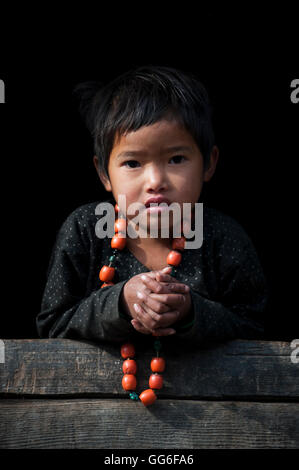 Ein kleines Mädchen spielt mit ihrer Halskette in der Manaslu Region von Nepal, Asien Stockfoto