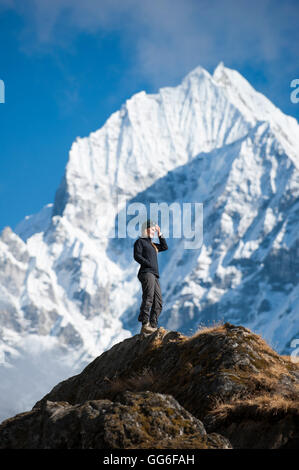 Ein Wanderer genießt die Aussicht über Namche in der Everest-Region mit Blick auf Thermserku in der Ferne, Himalaya, Nepal, Asien Stockfoto