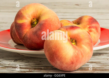 Frische reife saftige flachen Pfirsiche Obst auf einem hölzernen Hintergrund Stockfoto