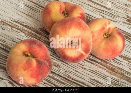 Frische reife saftige flachen Pfirsiche Obst auf einem hölzernen Hintergrund Stockfoto