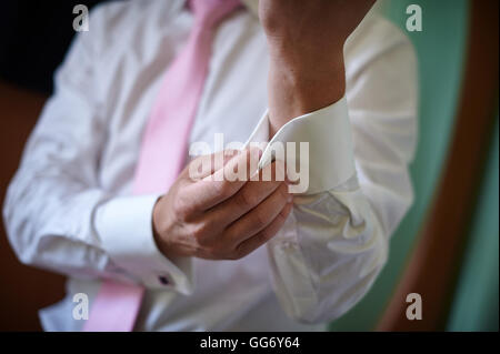 Mann in weißen Hemd mit rosa Krawatte in der Nähe von Fenster-Kleid-Manschettenknöpfe Stockfoto