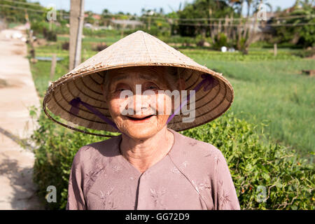 Alten vietnamesischen Dame konische Hut auf dem Lande in der Nähe von Hoi an ein. Stockfoto