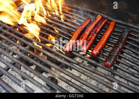 Hot Dogs, Kochen auf dem Grill grill in der Nähe von Flamme. Stockfoto