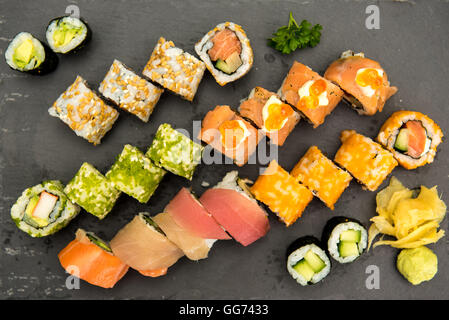 Sushi-Rollen auf einer schwarzen Platte Stockfoto