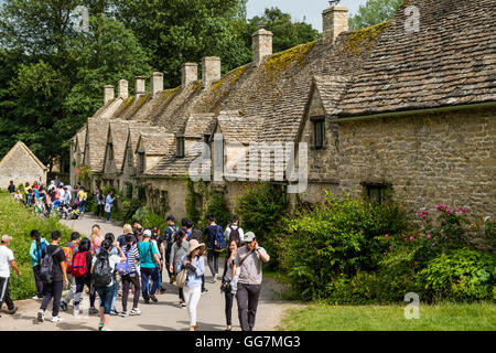 Viele asiatische Touristen in Arlington Row historischen ehemaligen Weber Cottages in Cotswolds Bibury, Gloucestershire, England Stockfoto