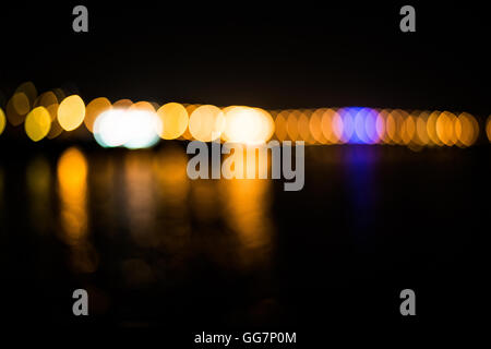 Bokeh der Straßenbeleuchtung in der Stadt mit Reflektion auf dem Fluss Stockfoto