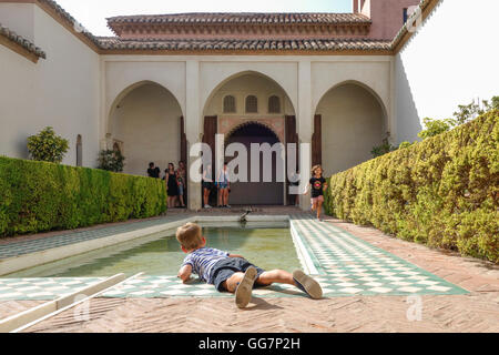 Junge spielt im Hofgarten des Cuartos de Granada, Alcazaba Festung, Malaga, Andalusien, Spanien Stockfoto