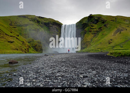 Mann stand vor Skogafoss Wasserfälle, Island Stockfoto