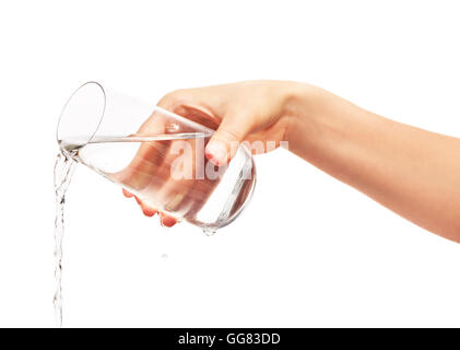 Wasser gießen aus vollen Trinkglas in Frauenhand isoliert auf weißem Hintergrund. Schneidepfad für Glas Rahmen enthalten. Stockfoto