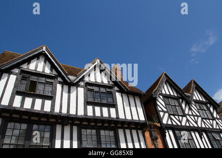 Eine Reihe von Tudor Stil Häuser in England mit traditionellen schwarz-weißen Fassaden unter einem klaren, blauen Himmel. Stockfoto