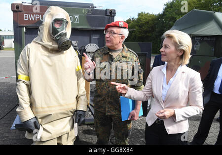 Bruchsal, Deutschland. 10. August 2016. Federal Verteidigungsministerin Ursula von der Leyen (CDU) steht in General-Dr. Speidel-Kaserne in Bruchsal, Deutschland, 10. August 2016. Sie macht einen Besuch des NBC Verteidigung Bataillons 750 und "Fox" gepanzertes Aufklärungsfahrzeug, stand neben ihr ist Kommandeur Oberst Henry Neumann (M) und ein Soldat, der besondere Schutzkleidung trägt. Foto: ULI DECK/Dpa/Alamy Live-Nachrichten Stockfoto