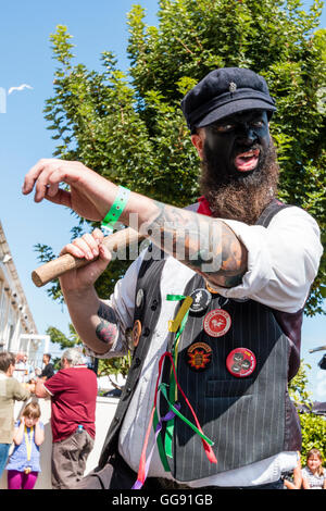 Broadstairs folk Week-Festival. Morris-Mann aus dem toten Pferd Morris und Broomdashers, mit geschwärztem Gesicht, zu Fuß durch, auf der Suche direkt auf den Betrachter, wie er geht. Niedrige Sicht. Stockfoto