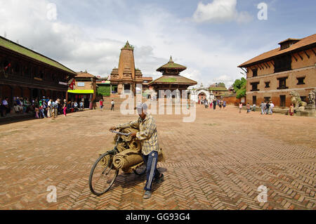 BHAKTAPUR, NP - ca. AUGUST 2012 - Mann mit Fahrrad in Durbar Square, ca. August 2012 in Bhaktapur. Bhaktapur wurde meist Stockfoto