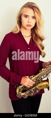 Blonde Teen Girl Holding Saxophon Stockfoto