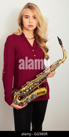 Blonde Teen Girl Holding Saxophon Stockfoto