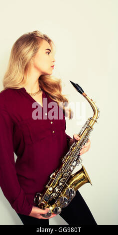 Profil von schönen blonden Teen Holding Saxophon Stockfoto