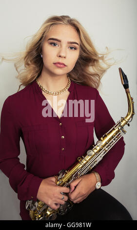 Blonde Teen Girl Holding Saxophon Stockfoto