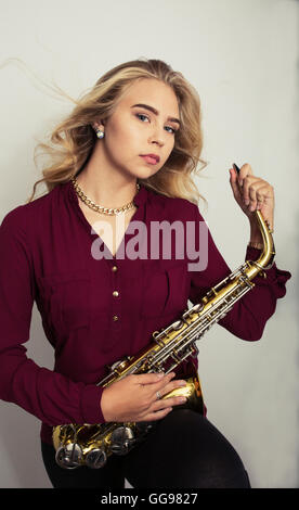 Blonde Teen Girl Holding Saxophon Stockfoto