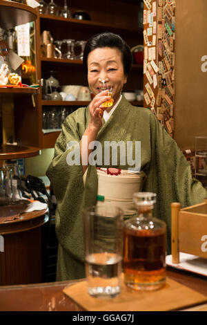Ältere Japanerin Kimono Sake zu trinken Stockfoto